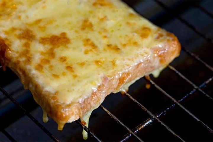 Cheese melted on toast in a rack