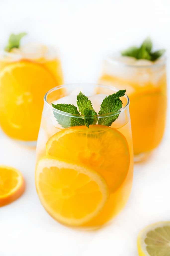 three glasses of citrus punch with a sprig of mint