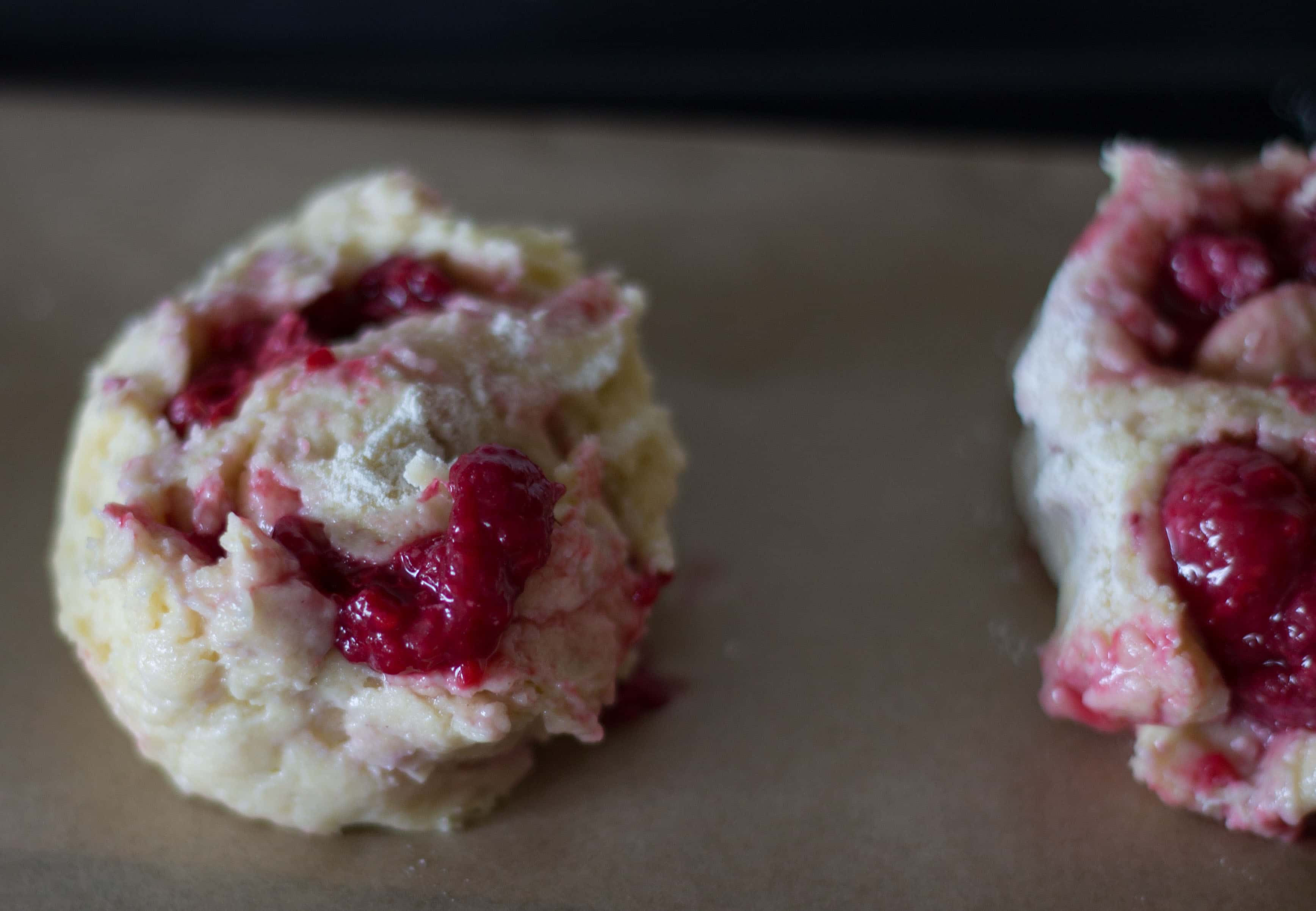 A close up of raw raspberry scones