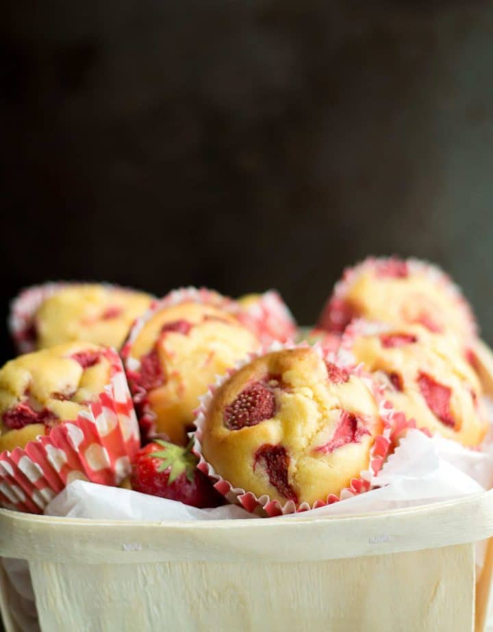 a basket full of bright and colorful strawberry cornbread muffins