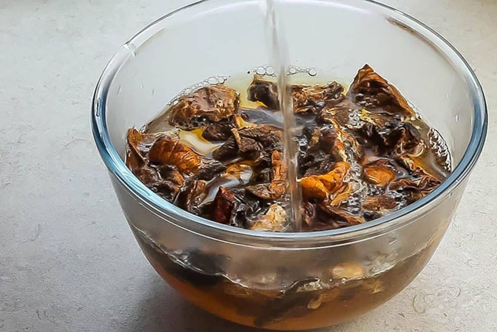 mushrooms soaking in a glass bowl of hot water