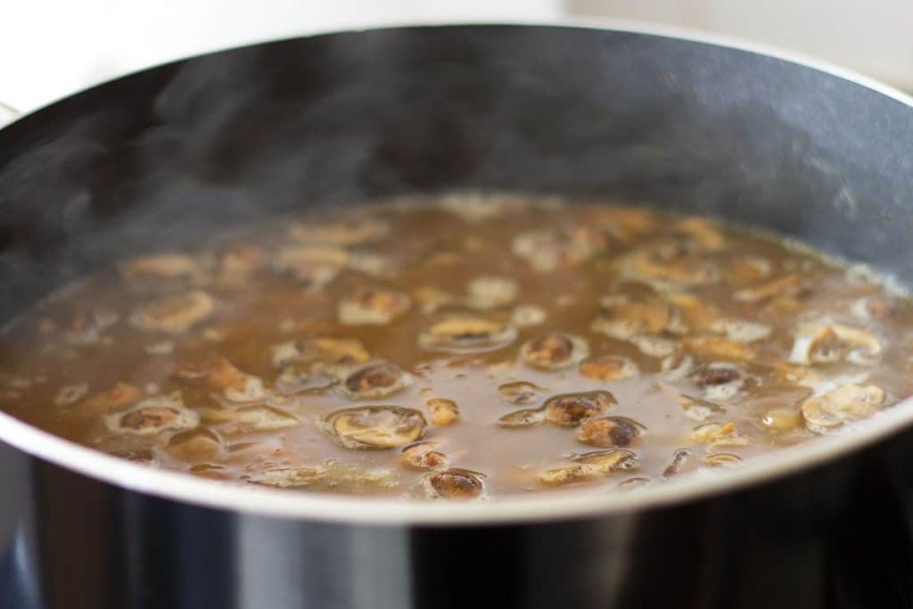mushrooms boiling in stock in a pan