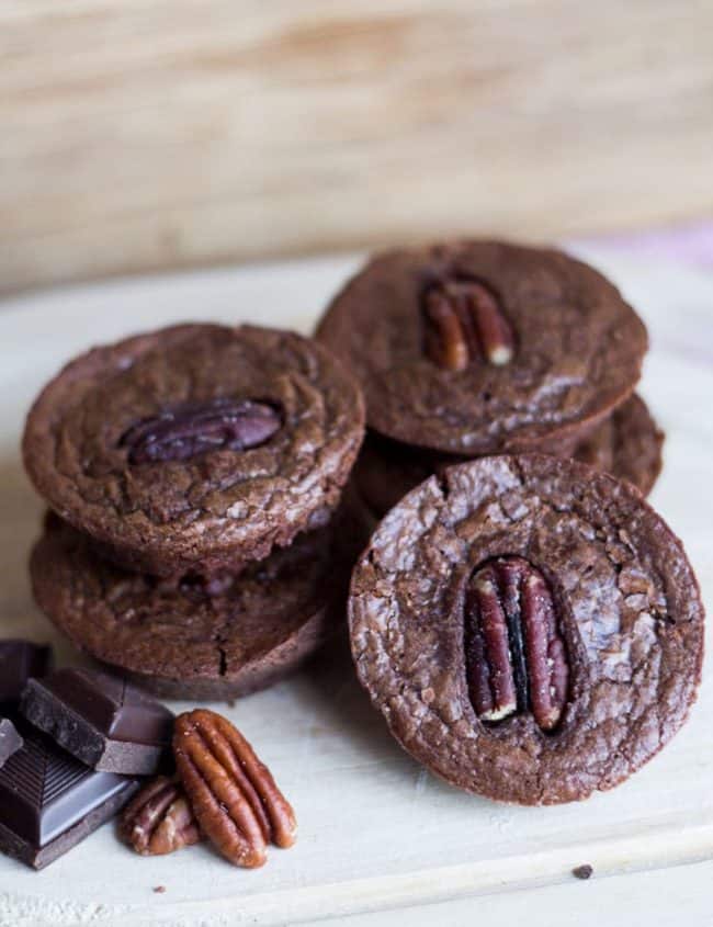 Triple Chocolate Brownie Bites on a plate ready to eat with chocolate and pecans surrounding them