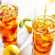 Two tall Glasses of Sweet Lemon Iced Tea with lots of ice and lemon slices