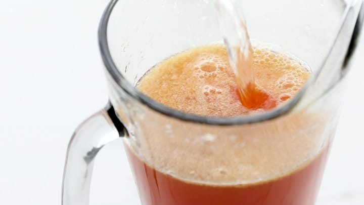 Water pouring into a pitcher of tea