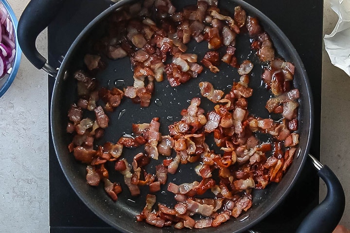 A pan with cooked, chopped bacon