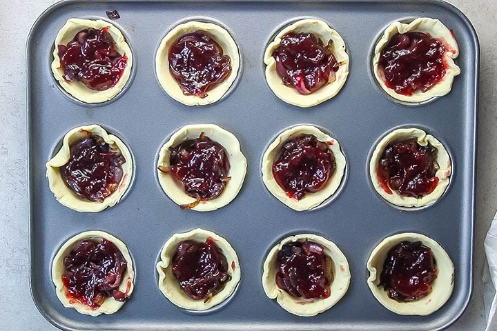 The cranberry sauce added to the cooked onions added to the pastry in the pan