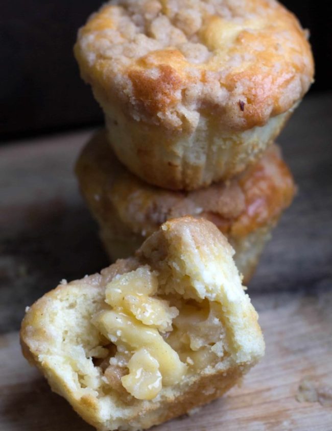 Apple cheesecake muffins with one muffin cut in half to show the centre
