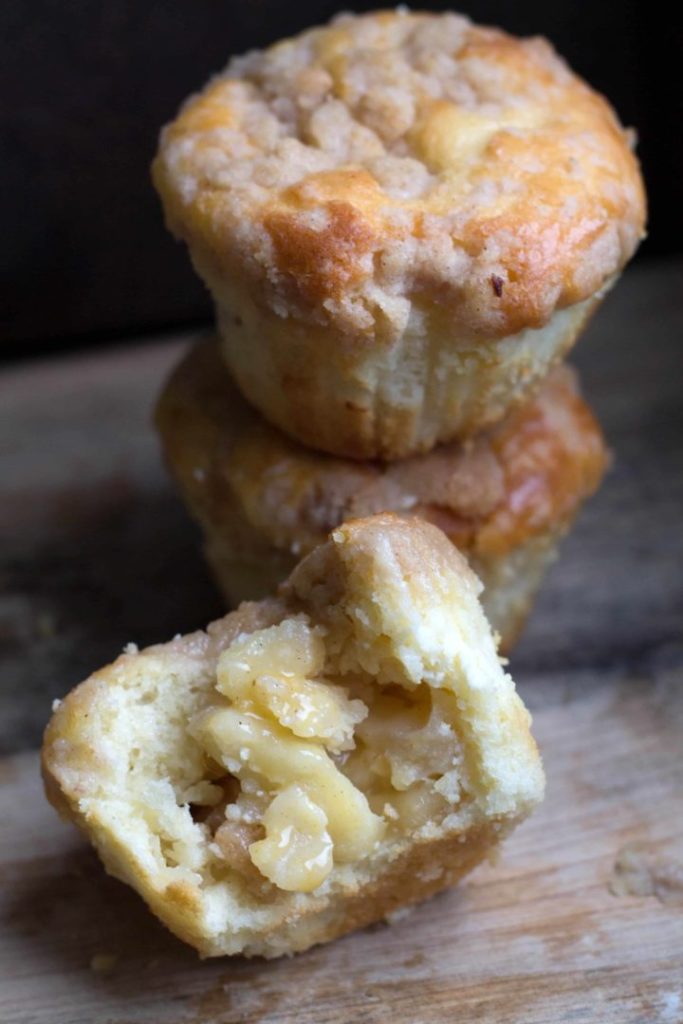 Apple cheesecake muffins with one muffin cut in half to show the centre