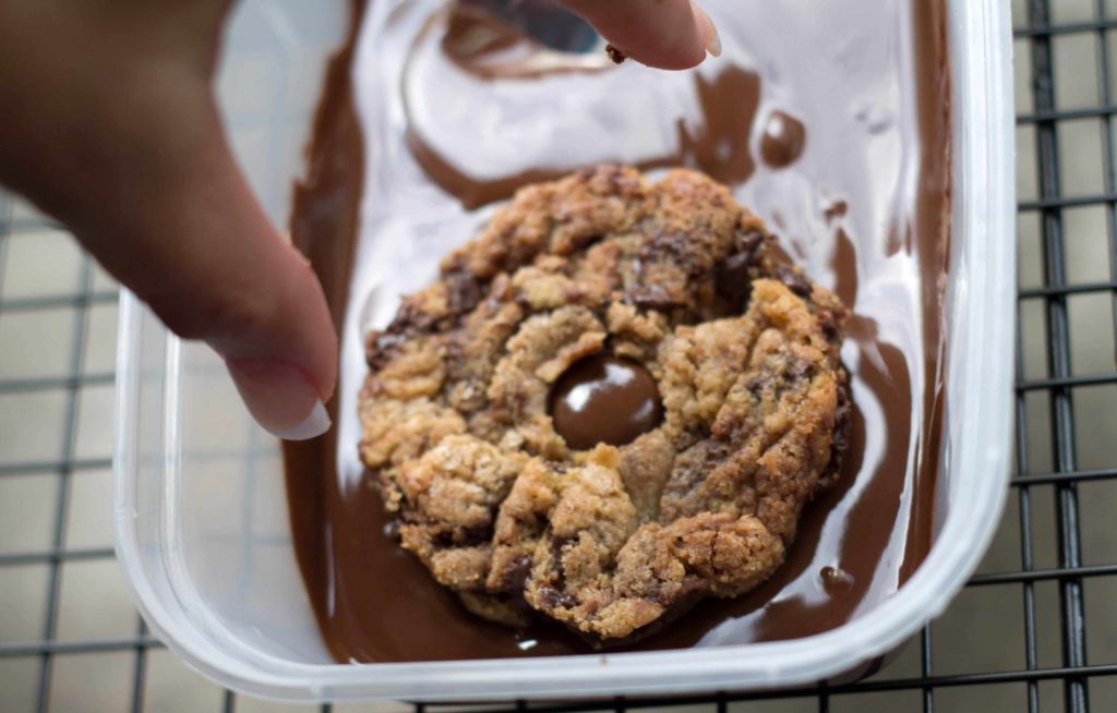 Nutella Cookies being dipped in melted chocolate