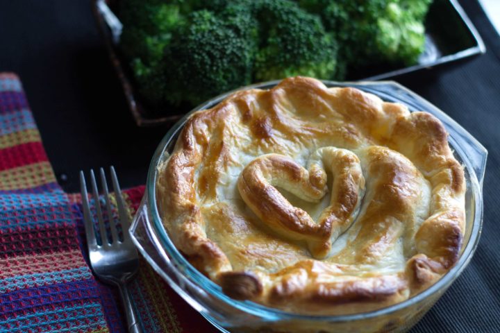 Easy Chicken Pot Pie out of the oven and ready to serve with a fork next to it and a bowl of broccoli in the background