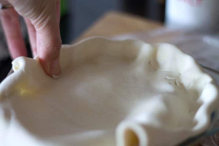 pastry being crimped around a dish 