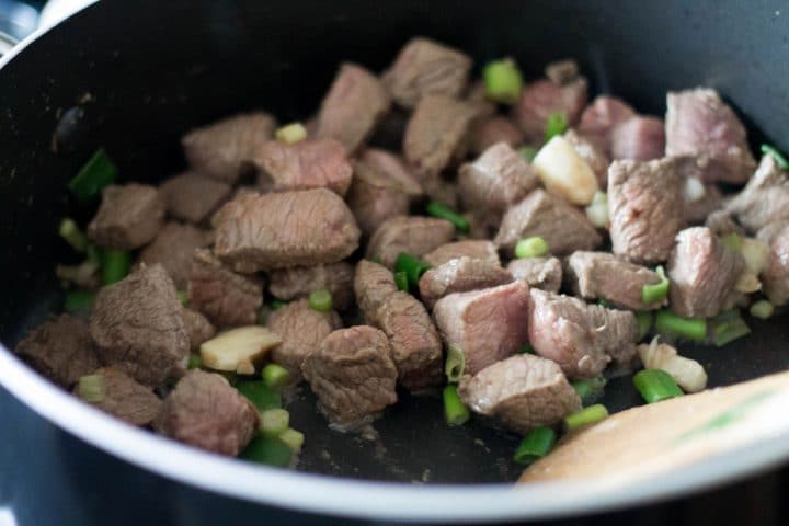 Chopped beef and spring greens in a pan