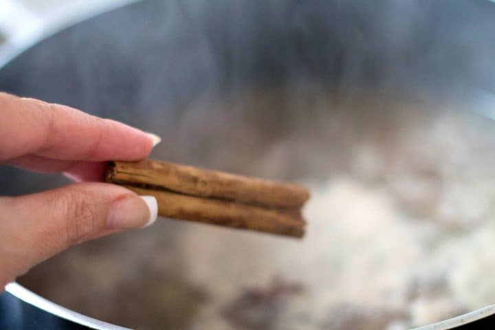 a cinnamon stick being added to the soup