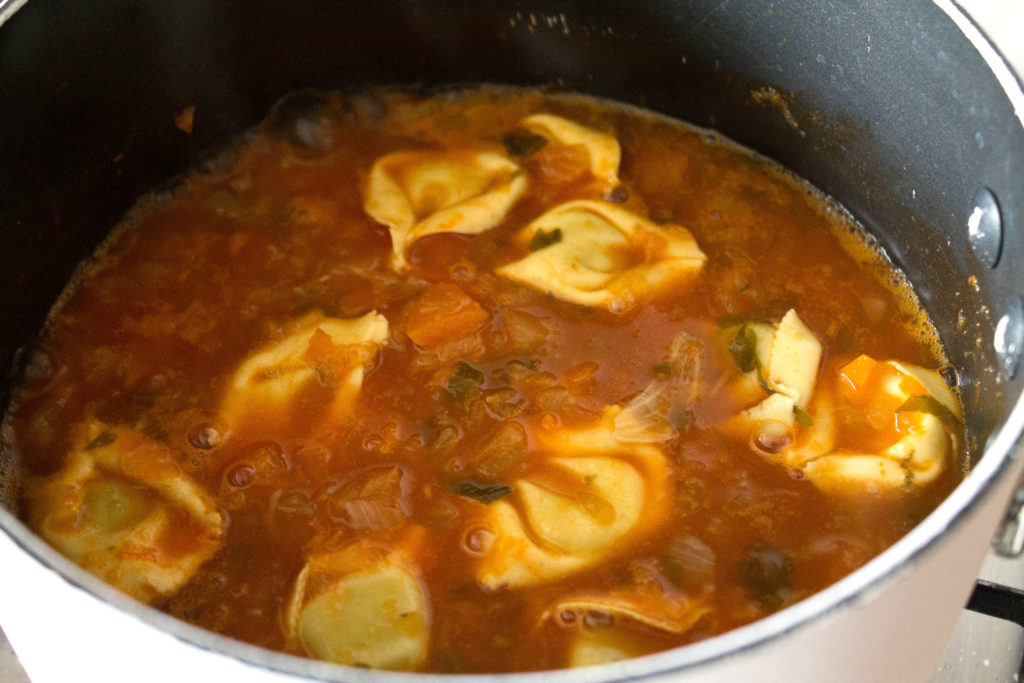 A bowl of soup, with Tortellini 