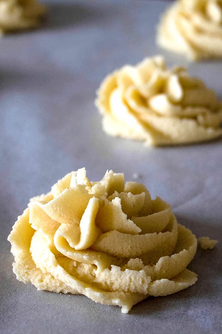 The dough piped onto the cookie sheet