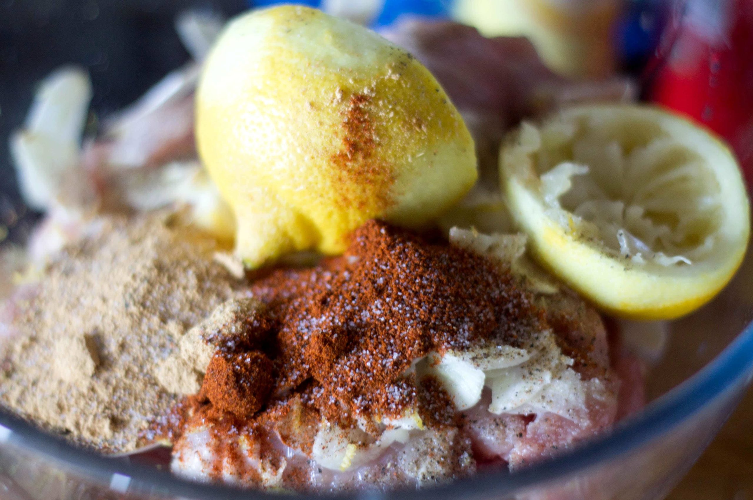 Moroccan Chicken ingredients in a bowl with a squeezed lemon on top