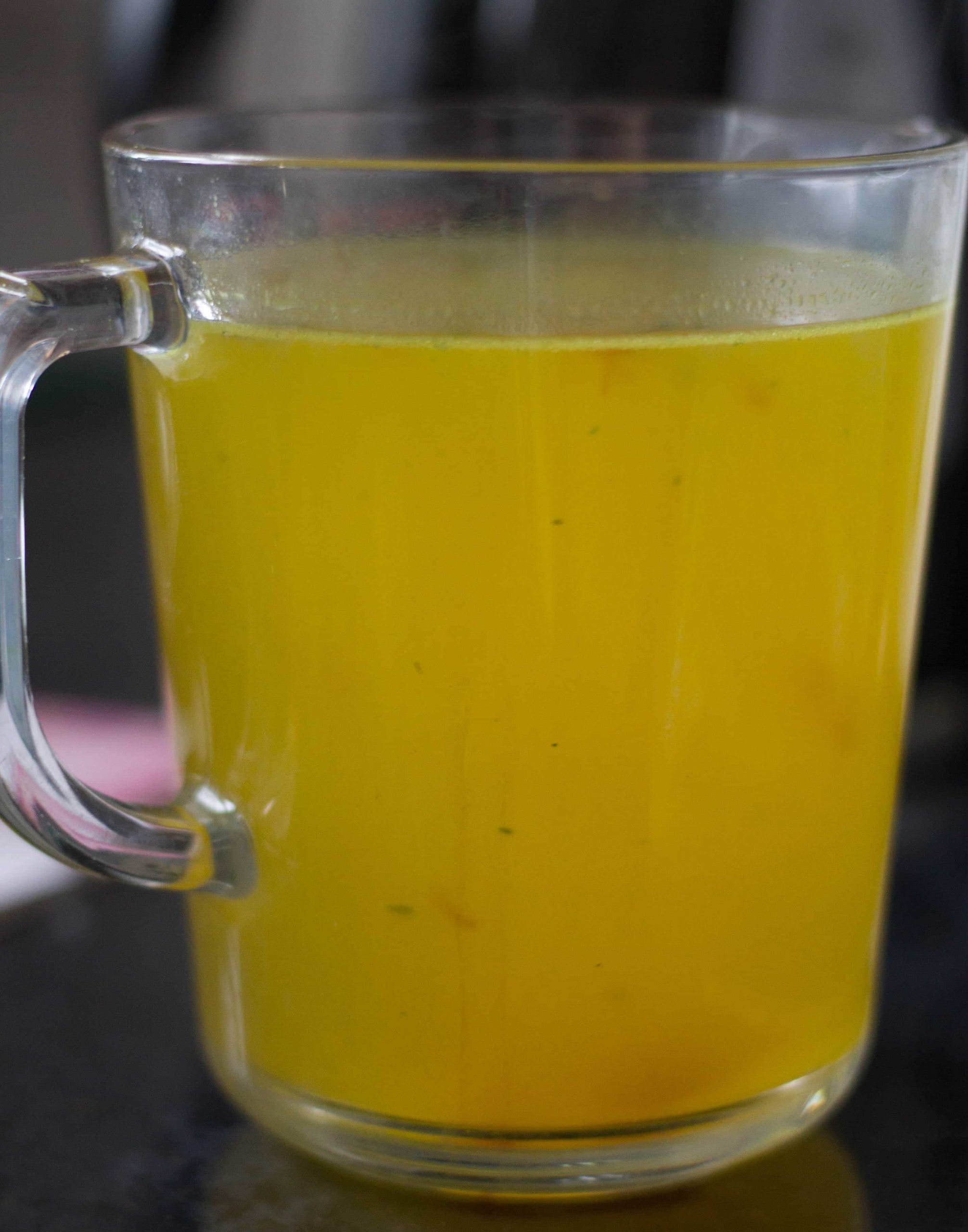 chicken stock in a glass measuring jug