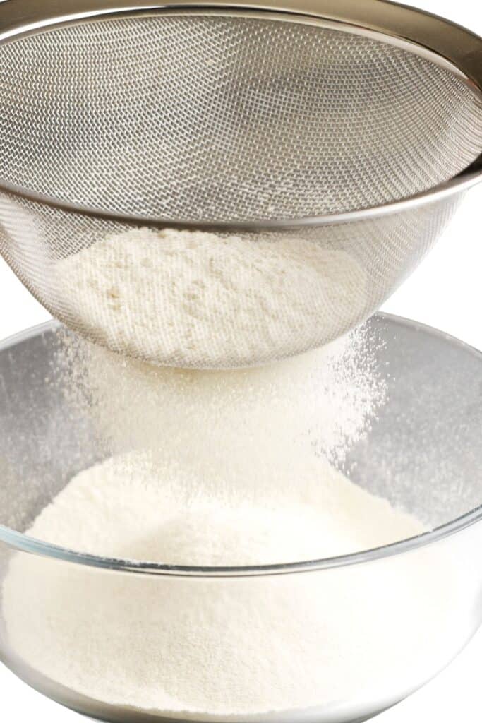 flour being sifted through a sifter