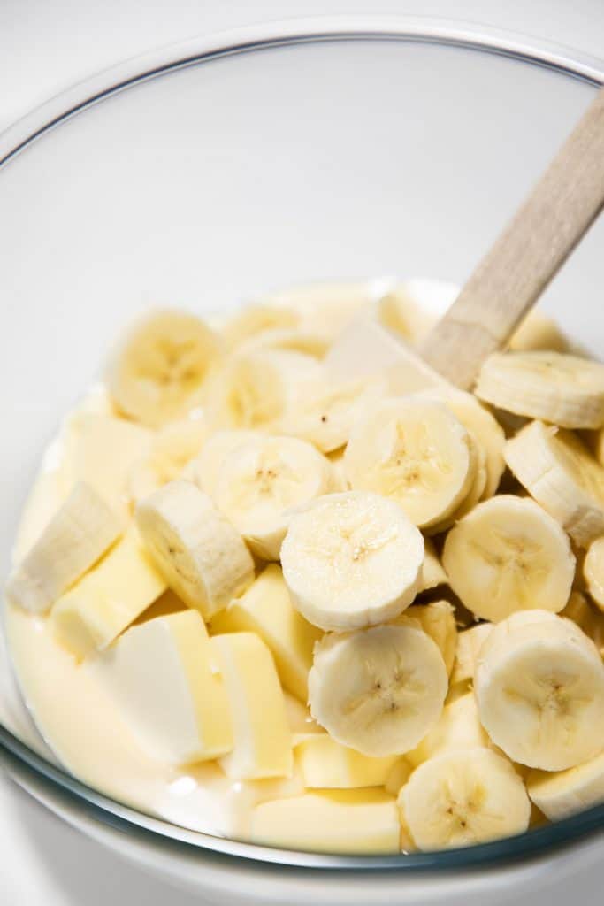 sliced bananas in a bowl with butter and condenced milk