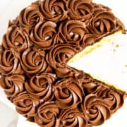 A cut Vanilla cake with chocolate rosette frosting