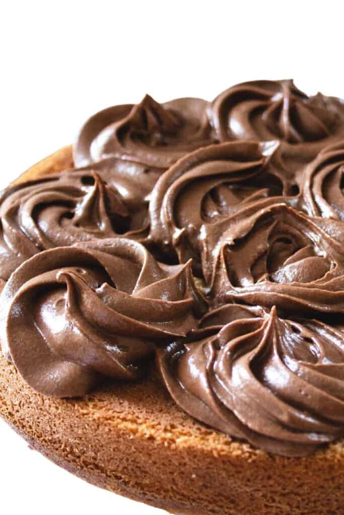 chocolate frosting piped on a cake in rosettes