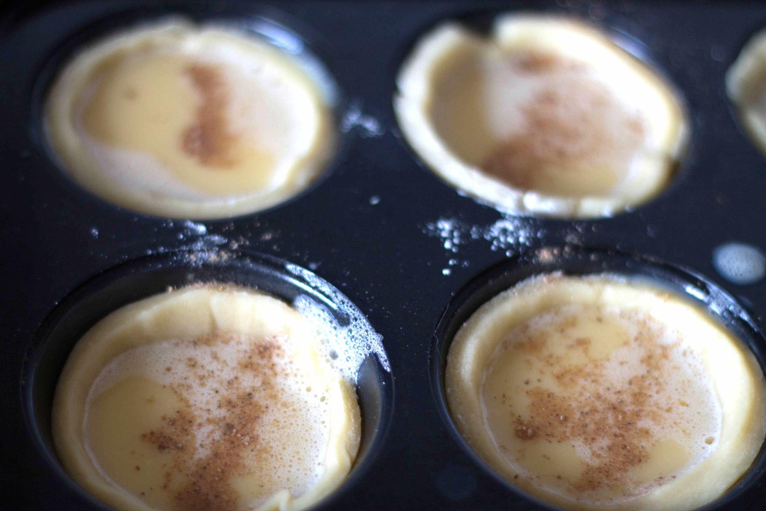 custard mixture poured into the pastry wells in the cupcake pan