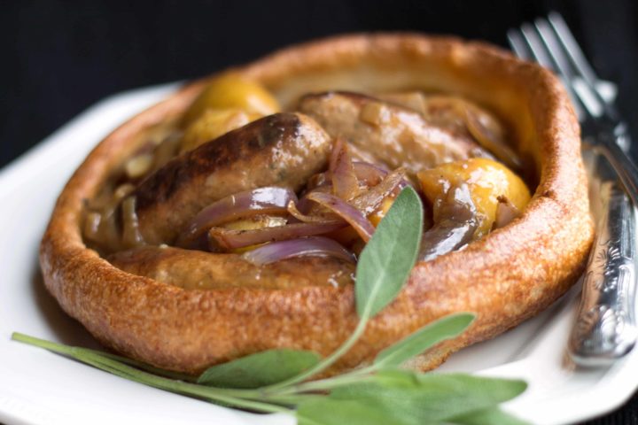 A plate of slow cooker apple sausage in onion gravy