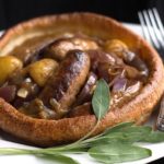 A plate of slow cooker apple sausage in onion gravy