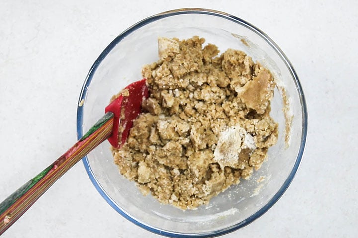The crumb topping mixture in a glass mixing bowl