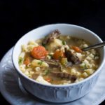 A bowl full of Slow Cooker Beef Brisket Soup with vegitables and small soup pasta added