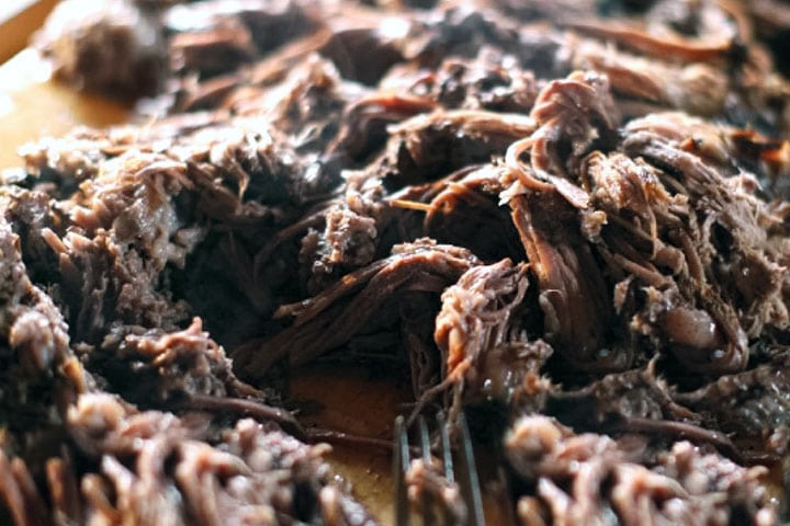 The Beef Brisket meat shredded with a fork