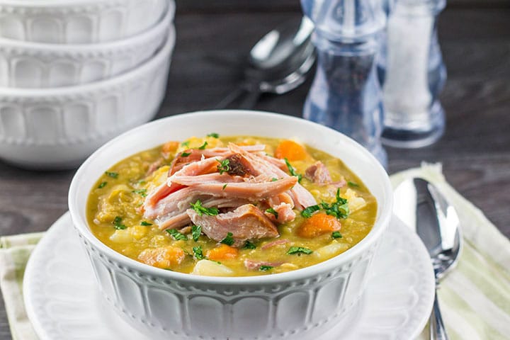 A bowl of vibrant, Split Pea and Ham Soup topped with shredded ham