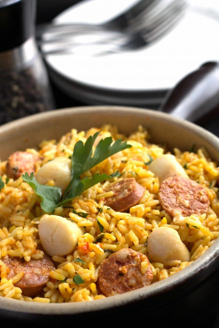 Easy Scallops & Chorizo Paella in a pan with parsley as garnish