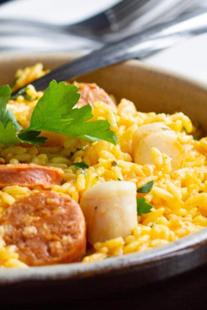 a dish of saffron rice with chorizo and scallops