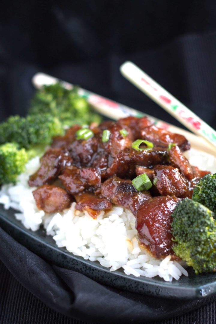 Slow Cooker Honey Soy Glazed Chicken on a bed of rice with broccoli and chop sticks beside it