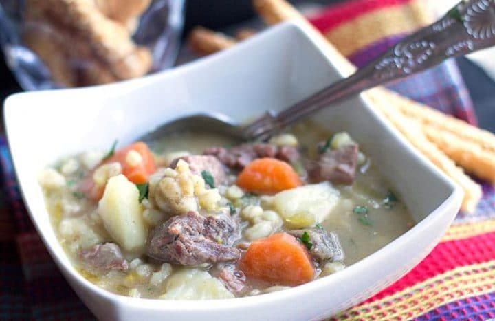 a bowl of Irish stew with a spoon in it