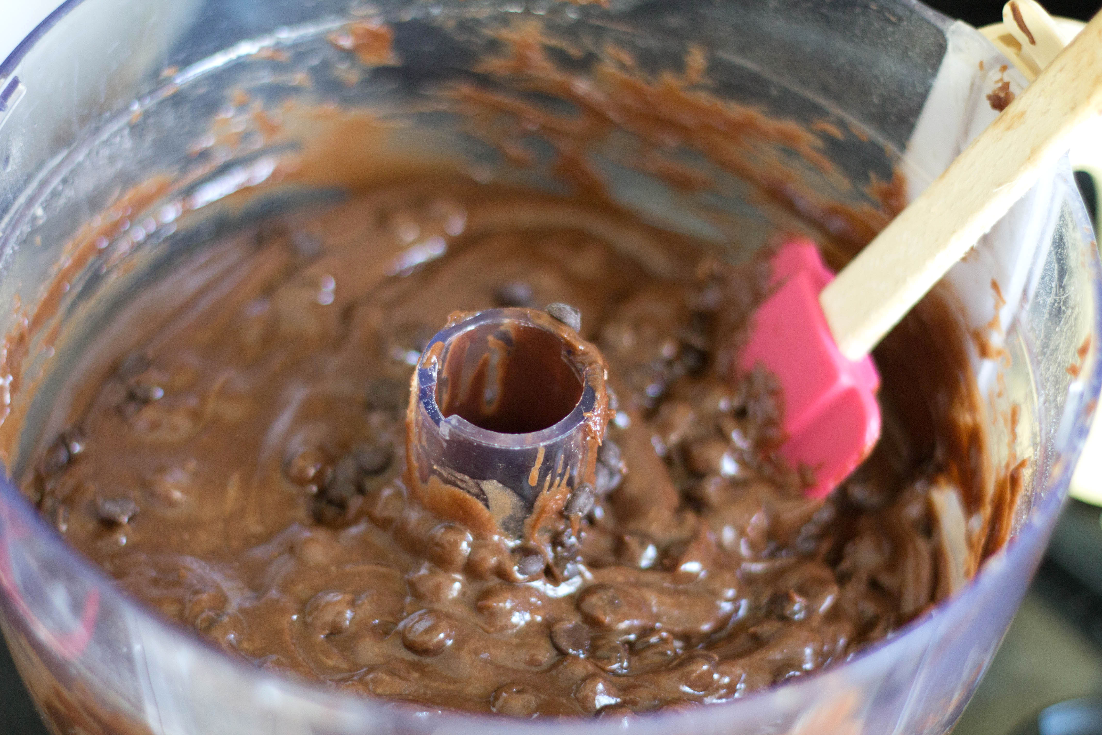 Chocolate Chip Banana Cake batter in a food mixer with a spatula