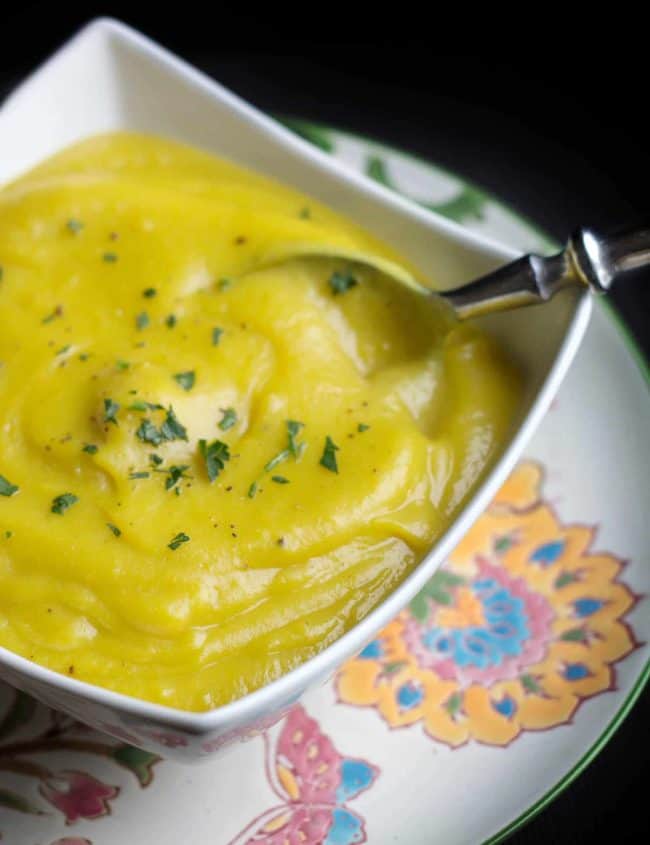Low Fat Creamy Cauliflower Saffron Soup scattered with herbs in a bowl