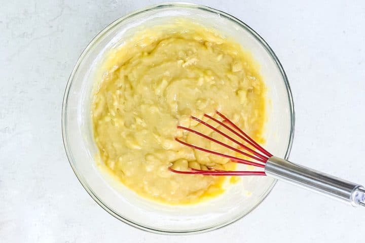 the batter in a mixing bowl with a red whisk