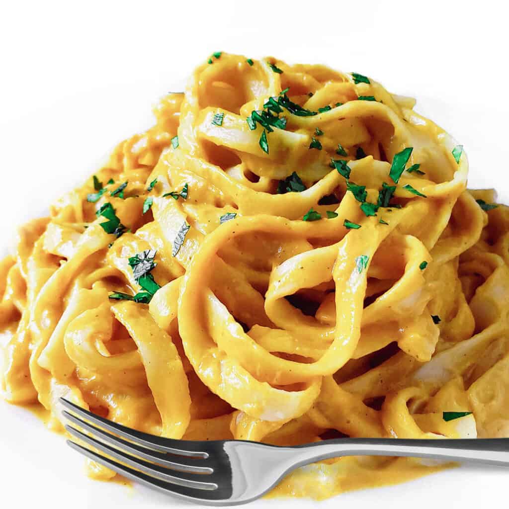 a plate of Tagliarini with Saffron Cream Sauce with herbs scattered on top