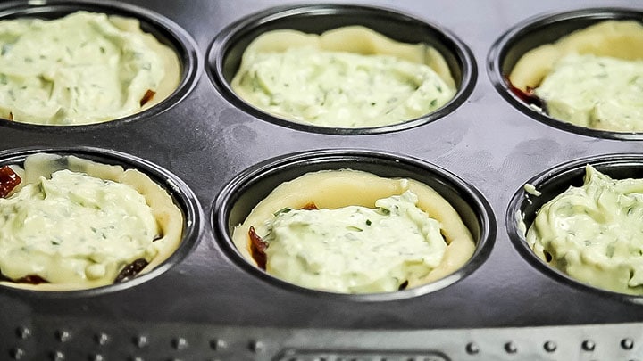 The feta mixture added to the onions in the pan