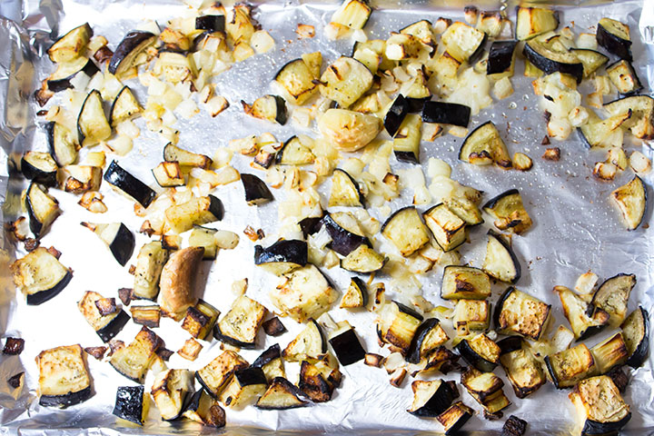 The freshly roasted eggplant, onion and garlic clove on the pan