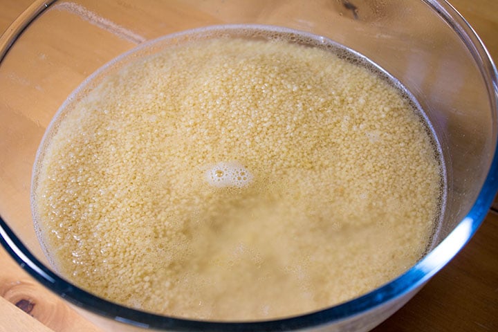 The couscous in a glass bowl with the water covering it