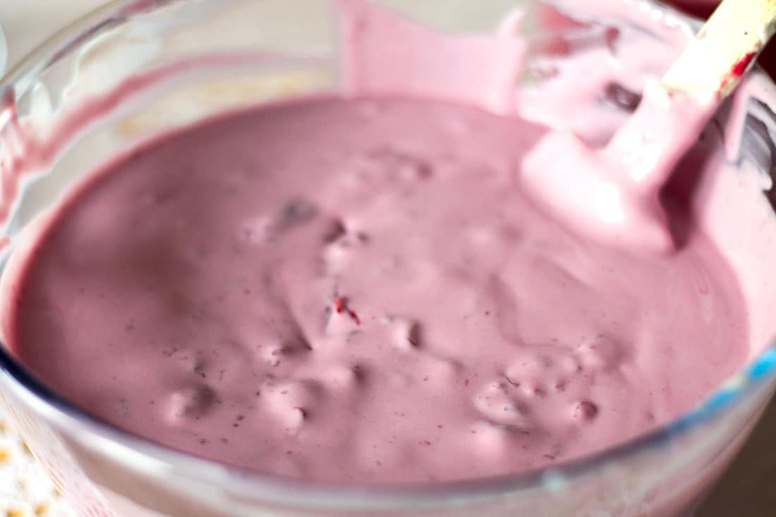 The ice cream mixture in a glass mixing bowl