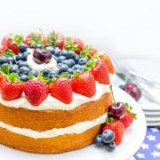 Vanilla Cream Sponge Cake on a cake plate topped with fresh berries