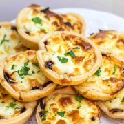 Feta and Caramelized Onion Tarts piled high on a plate