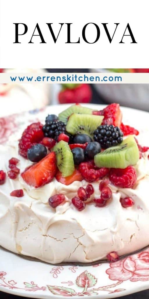 a pavlova covered in fruit, ready to eat