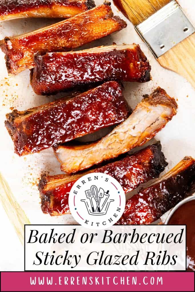 A close-up of Baked or Barbecued Sticky Glazed Ribs, sliced and arranged on a white surface with a bowl of barbecue sauce and a meat cleaver. Text reads: "Baked or Barbecued Sticky Glazed Ribs" and "www.errenskitchen.com.