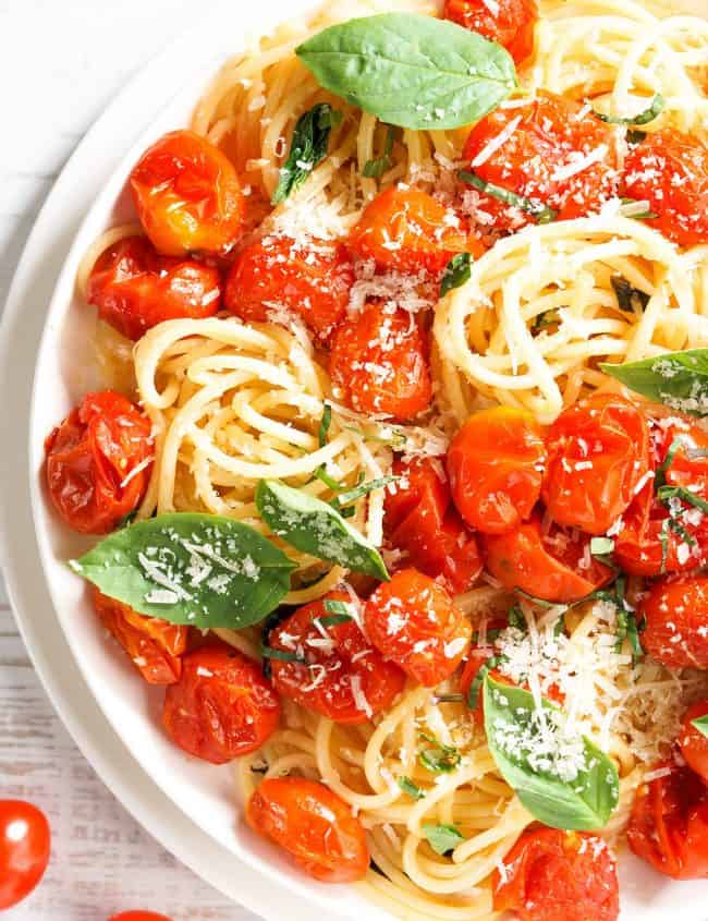 spaghetti with roasted cherry tomato and fresh basil in a white plate